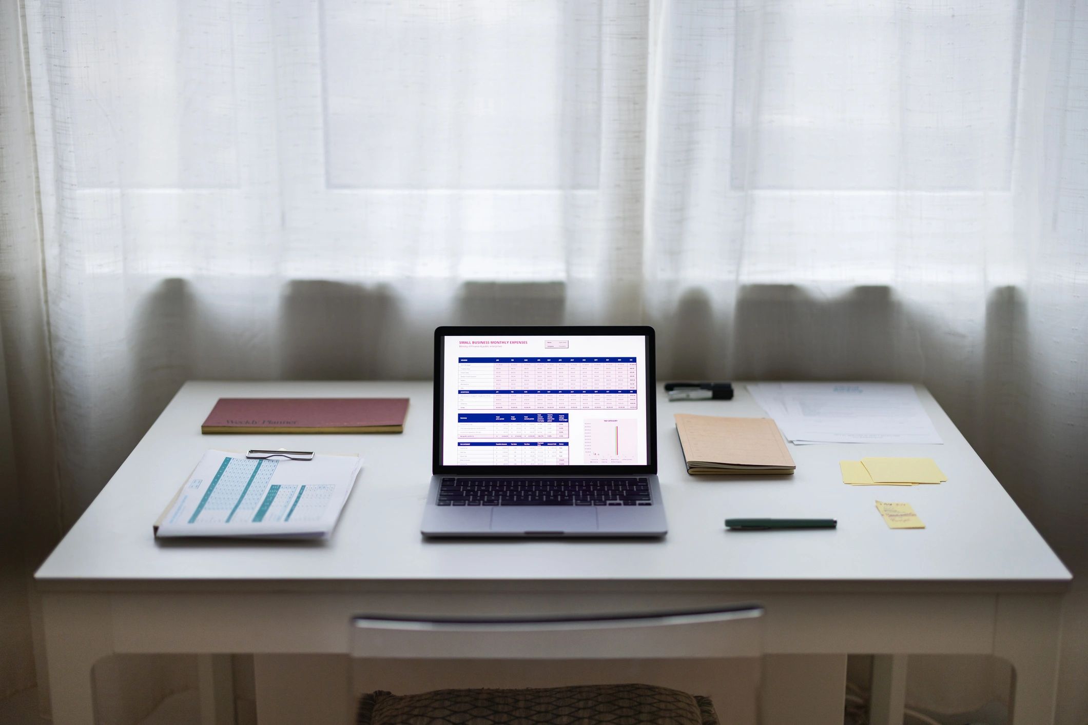 Home office desk with laptop and planning papers